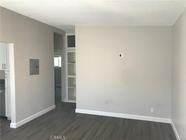 539 E 223rd St, Carson, CA 90745 - empty room with dark wood finished floors, baseboards, electric panel, and built in features