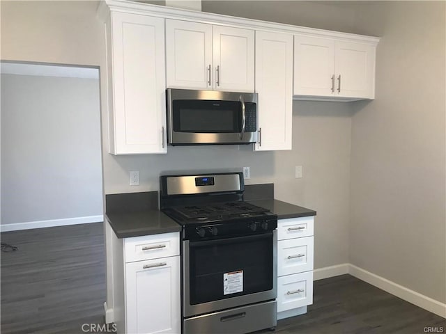 539 E 223rd St, Carson, CA 90745 - kitchen featuring appliances with stainless steel finishes, dark wood-style flooring, dark countertops, and white cabinetry