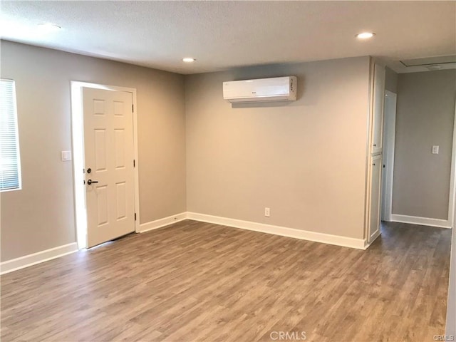 539 E 223rd St, Carson, CA 90745 - unfurnished room with a wall mounted AC, wood finished floors, recessed lighting, baseboards, and a textured ceiling