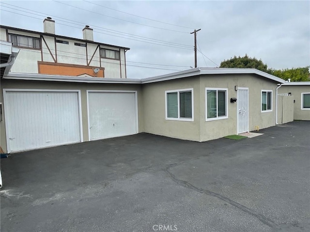 539 E 223rd St, Carson, CA 90745 - view of front of home featuring a chimney, stucco siding, asphalt driveway, and an attached garage