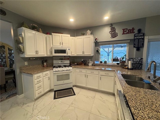 kitchen with white cabinetry, a sink, marble finish floor, recessed lighting, and white appliances