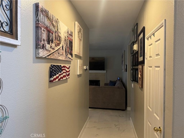hall with baseboards and marble finish floor