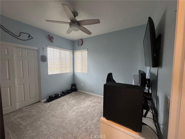 office featuring carpet floors, a ceiling fan, and baseboards