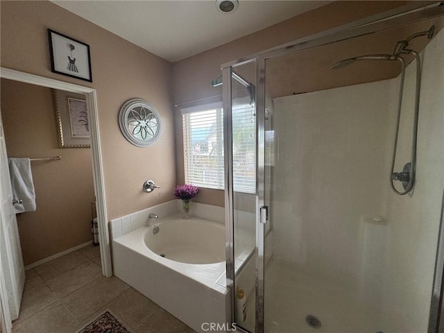 full bath with tile patterned floors, baseboards, a bath, and a stall shower