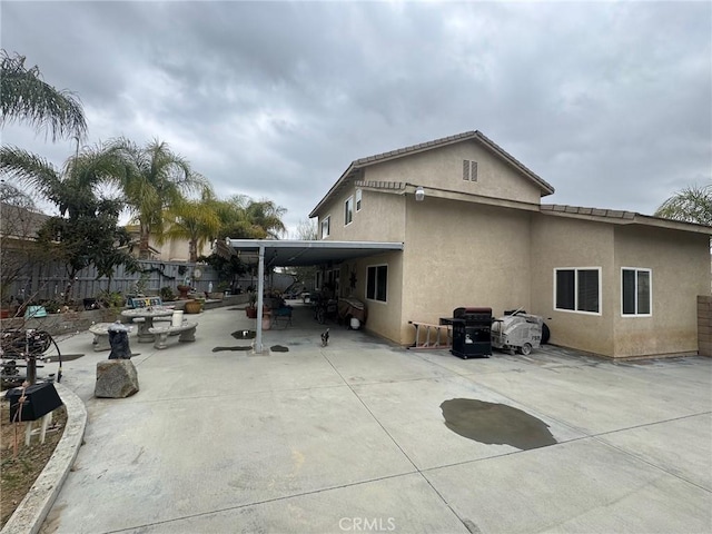 back of property with fence, a patio area, and stucco siding