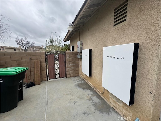 view of home's exterior with a gate, stucco siding, and fence