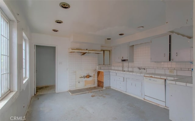 kitchen with tile counters, decorative backsplash, a healthy amount of sunlight, and dishwasher