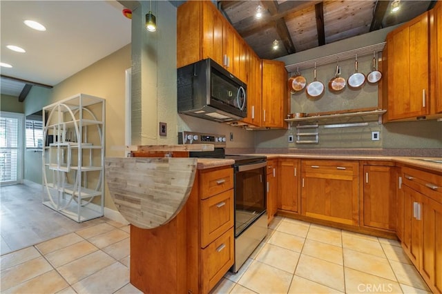 kitchen featuring beam ceiling, brown cabinetry, light tile patterned floors, and electric stove