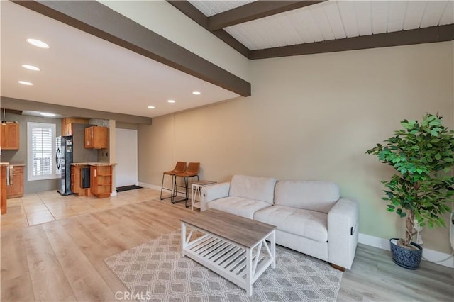 living area featuring light wood finished floors, recessed lighting, and beam ceiling