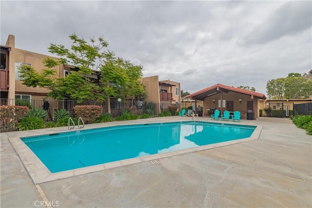 community pool featuring a patio area and fence