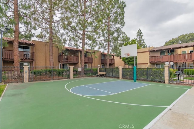 view of sport court with fence, community basketball court, and a residential view