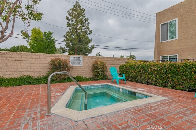 view of pool with a patio area, a community hot tub, and fence
