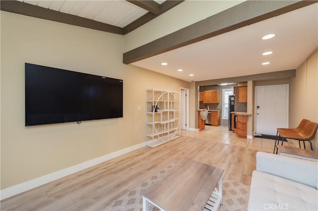 unfurnished living room with recessed lighting, baseboards, beam ceiling, and light wood-style floors