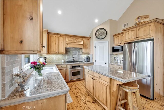 1119 Brentwood Dr, Lake Arrowhead, CA 92352 - kitchen featuring appliances with stainless steel finishes, a sink, light brown cabinets, a center island, and vaulted ceiling