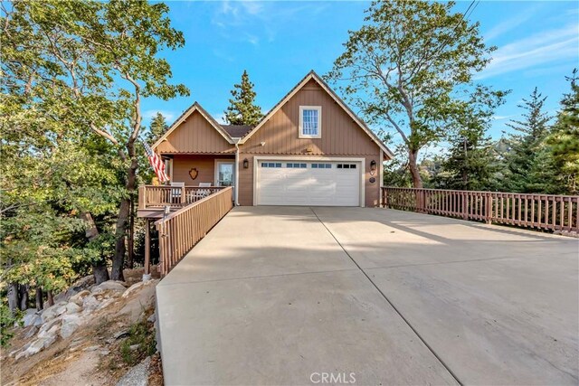 1119 Brentwood Dr, Lake Arrowhead, CA 92352 - chalet / cabin with board and batten siding, an attached garage, and driveway