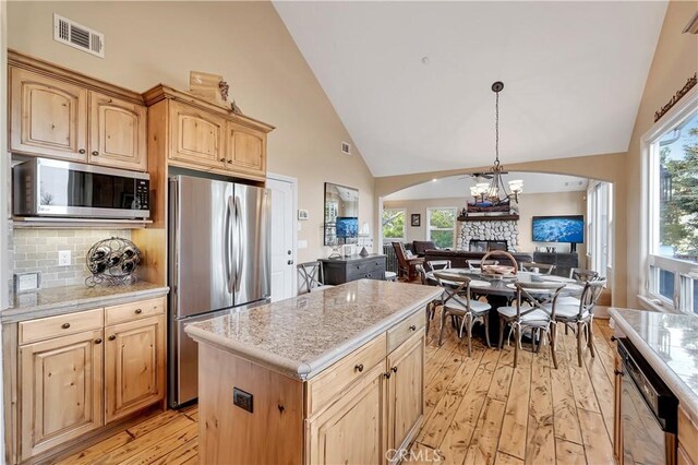 1119 Brentwood Dr, Lake Arrowhead, CA 92352 - kitchen with a stone fireplace, visible vents, arched walkways, light wood-style floors, and stainless steel appliances