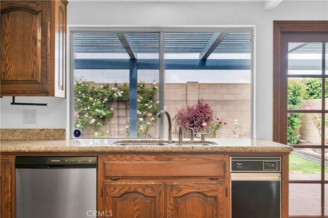 8913 La Dona Ct, Fountain Valley, CA 92708 - kitchen featuring stainless steel dishwasher, light stone countertops, brown cabinetry, and a sink