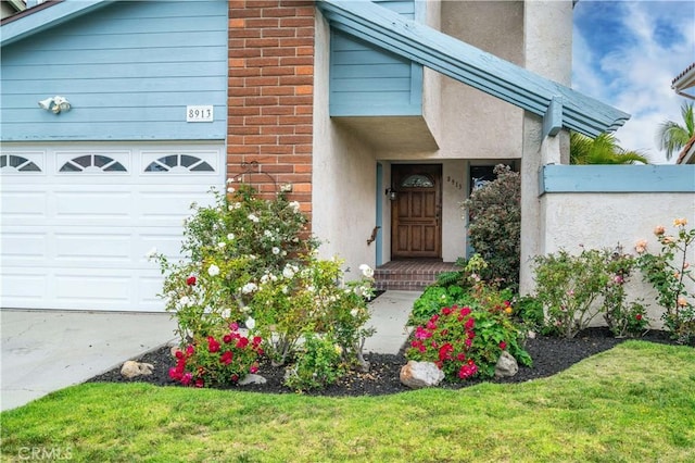 8913 La Dona Ct, Fountain Valley, CA 92708 - view of exterior entry with a lawn, stucco siding, and a garage