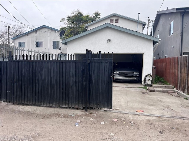 exterior space with an attached garage, driveway, fence private yard, and stucco siding