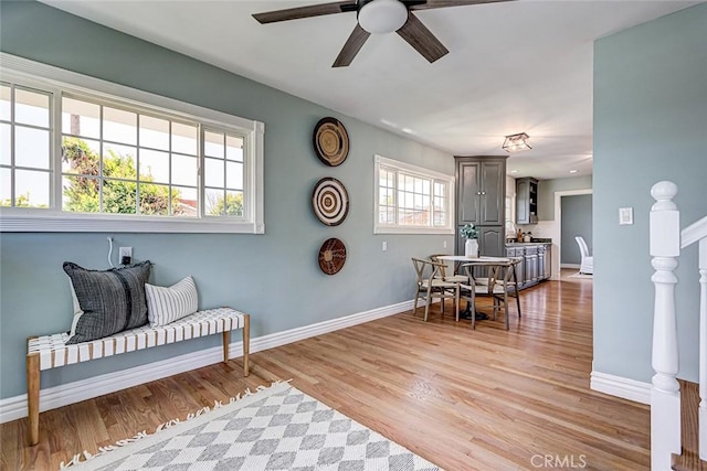 interior space with baseboards, light wood finished floors, and ceiling fan