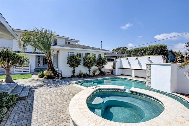 view of swimming pool featuring a pool with connected hot tub and a patio area