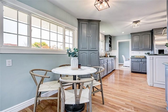 dining area featuring light wood-style floors and baseboards