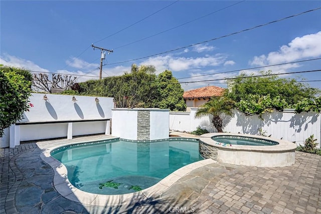 view of pool featuring fence and a pool with connected hot tub