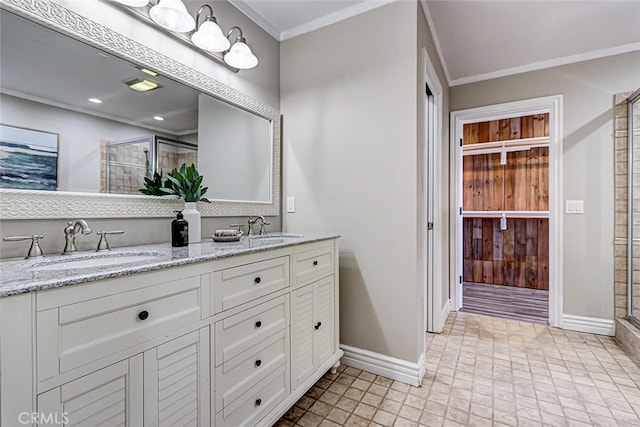 bathroom featuring a sink, baseboards, crown molding, and a shower stall