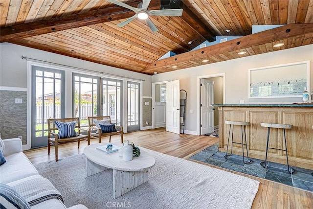 living area featuring wood ceiling, lofted ceiling with beams, a ceiling fan, and wood finished floors