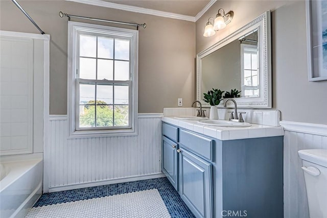 full bath with a sink, wainscoting, and toilet