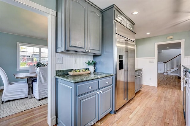 kitchen with recessed lighting, light wood finished floors, stainless steel built in fridge, and gray cabinetry