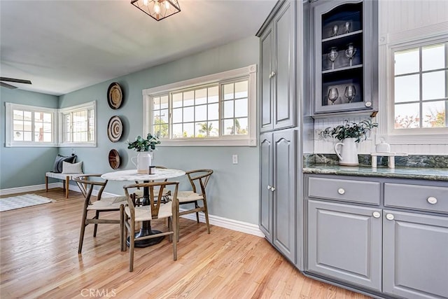 dining room featuring baseboards, light wood finished floors, and a wealth of natural light