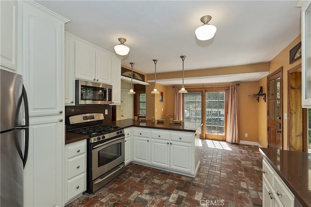 242 Holiday Dr, Lake Arrowhead, CA 92352 - kitchen featuring dark countertops, appliances with stainless steel finishes, baseboards, a peninsula, and brick floor