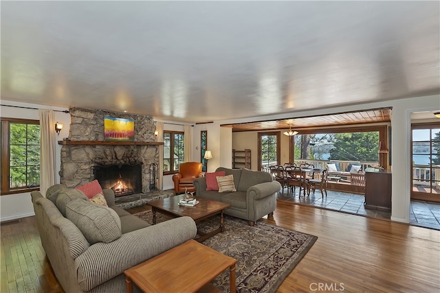 242 Holiday Dr, Lake Arrowhead, CA 92352 - living room with a stone fireplace, plenty of natural light, and hardwood / wood-style flooring