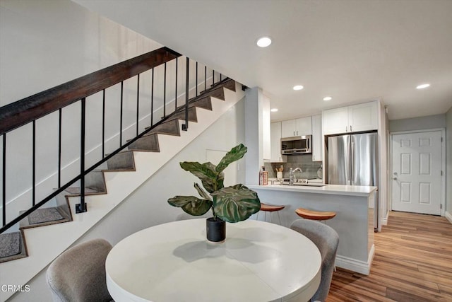 385 E Surfside Dr, Port Hueneme, CA 93041 - dining room featuring baseboards, recessed lighting, wood finished floors, and stairs