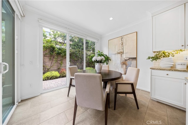 dining space featuring baseboards, ornamental molding, and light tile patterned floors
