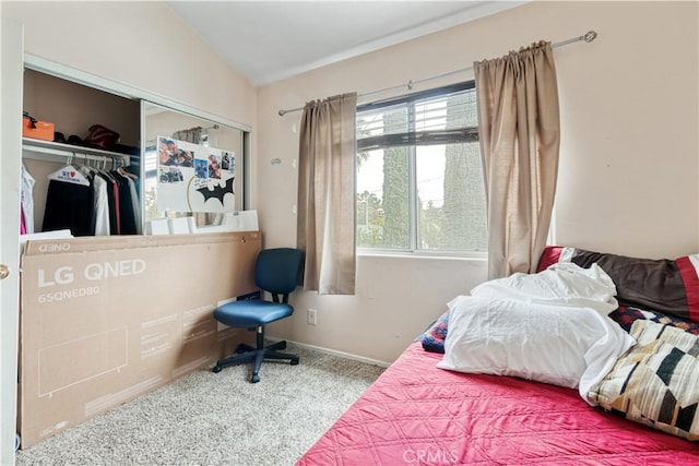 carpeted bedroom featuring vaulted ceiling, a closet, and baseboards