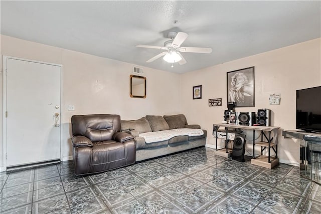 living area with ceiling fan and baseboards