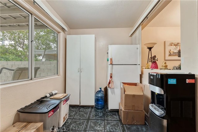 kitchen featuring freestanding refrigerator and dark flooring