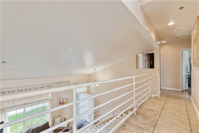corridor with light tile patterned flooring, baseboards, recessed lighting, and an upstairs landing