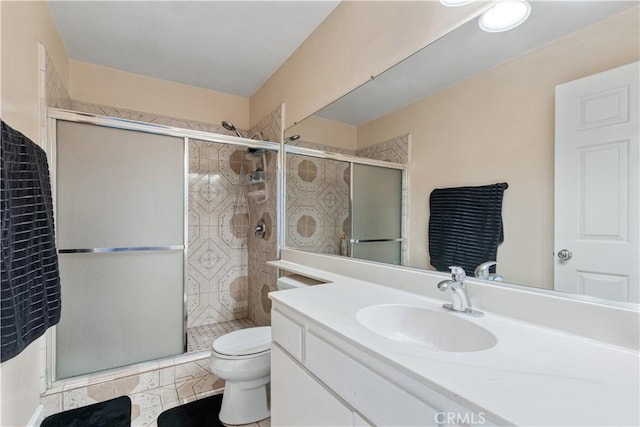 full bath featuring toilet, a stall shower, and vanity