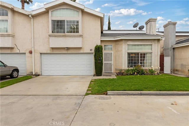 view of front of home with stucco siding, an attached garage, and a front yard