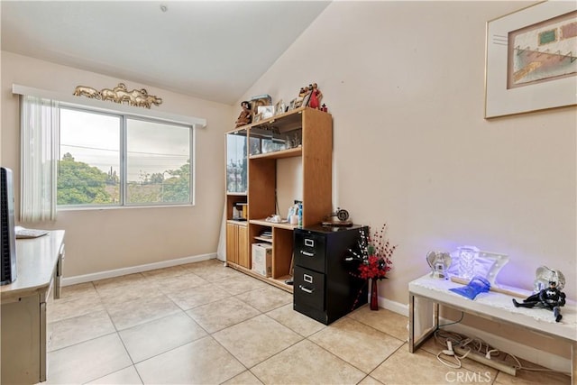 office space featuring lofted ceiling, light tile patterned floors, and baseboards
