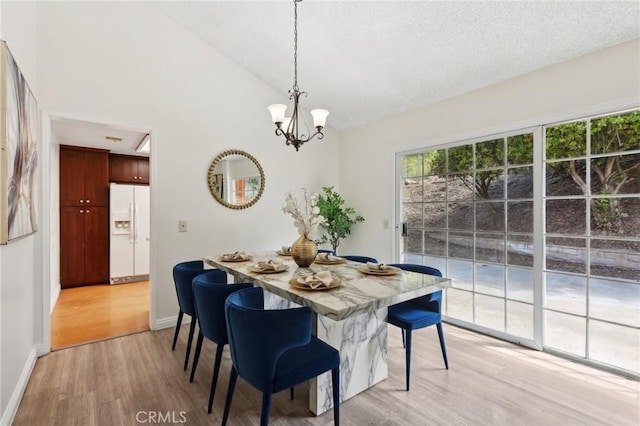 20905 Trigger Ln, Diamond Bar, CA 91765 - dining area featuring light wood-style flooring, a chandelier, baseboards, vaulted ceiling, and a textured ceiling
