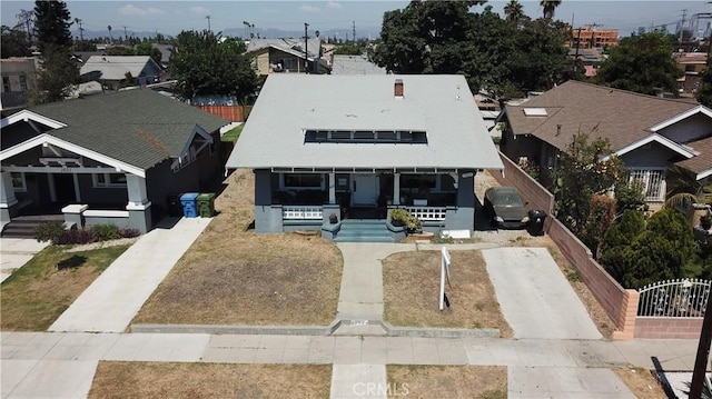 view of front of house featuring a residential view, fence, and a porch