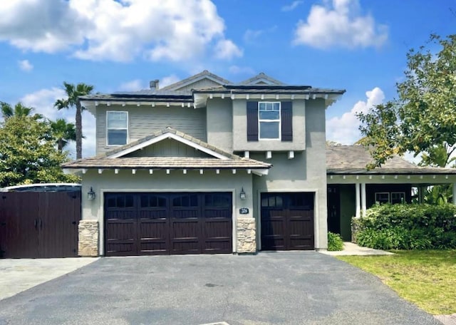 view of front of property with a garage, stone siding, stucco siding, and aphalt driveway