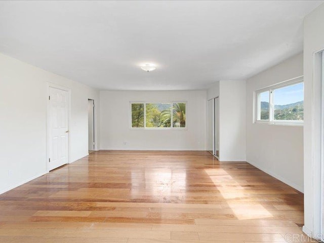 empty room featuring light wood-type flooring and baseboards