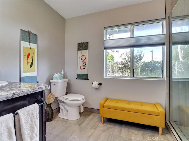 full bathroom with vanity, toilet, an enclosed shower, and baseboards