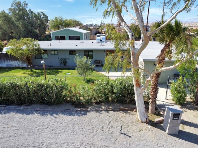 view of front facade featuring a front yard and fence