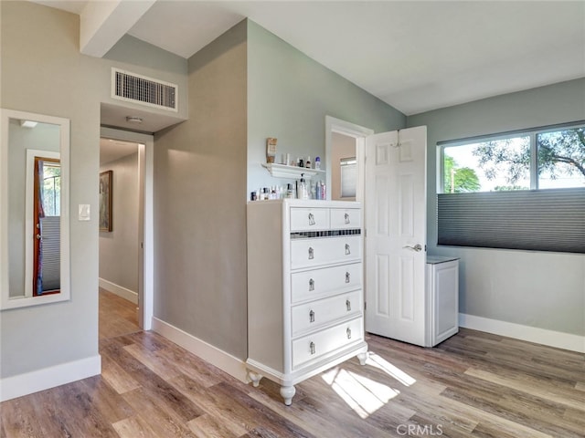 interior space with baseboards, visible vents, and wood finished floors